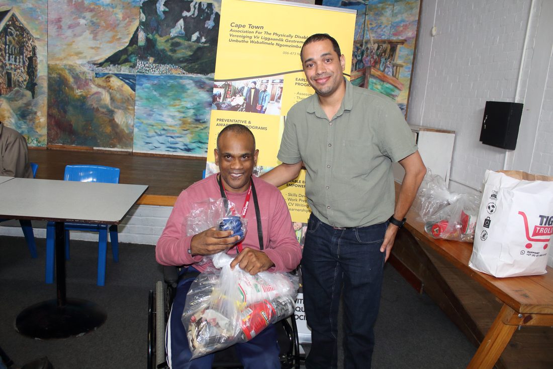 A member receiving relief parcels from CTAPD staff at a community handover